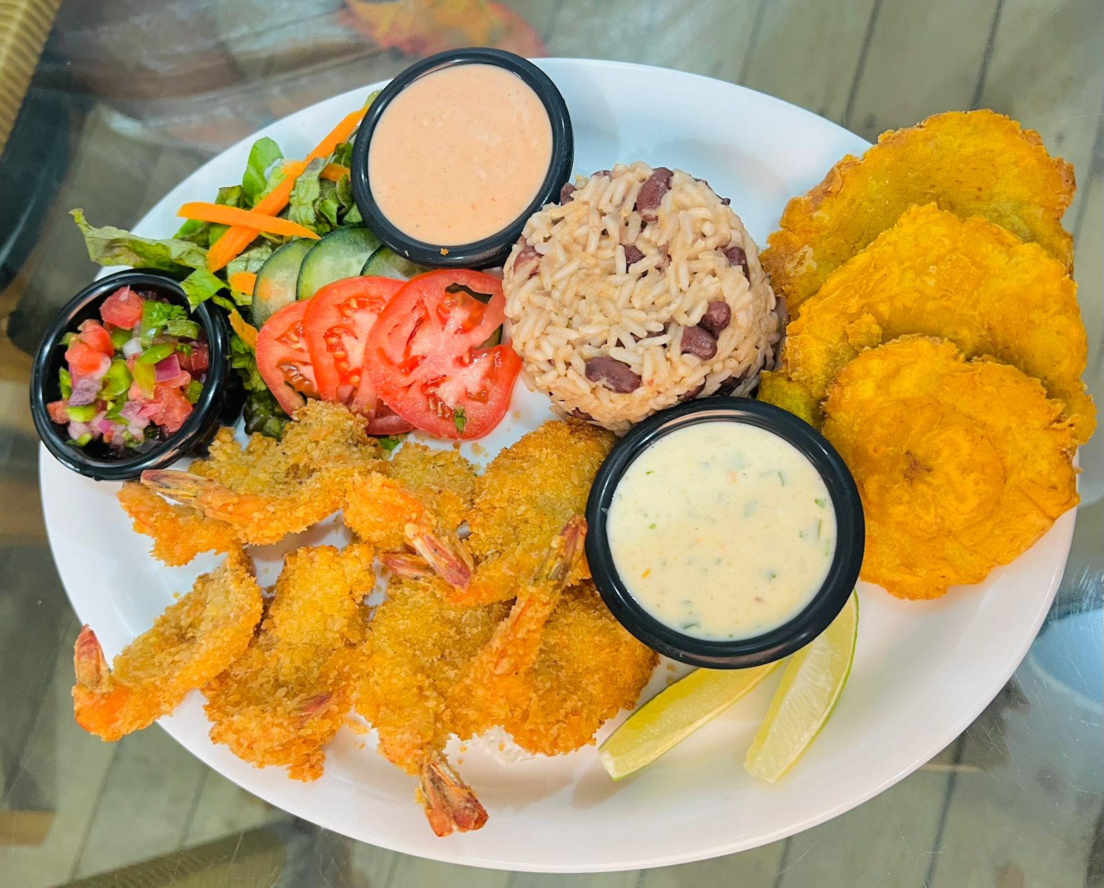 Plato de camarones empanizados con arroz, ensalada y tajadas